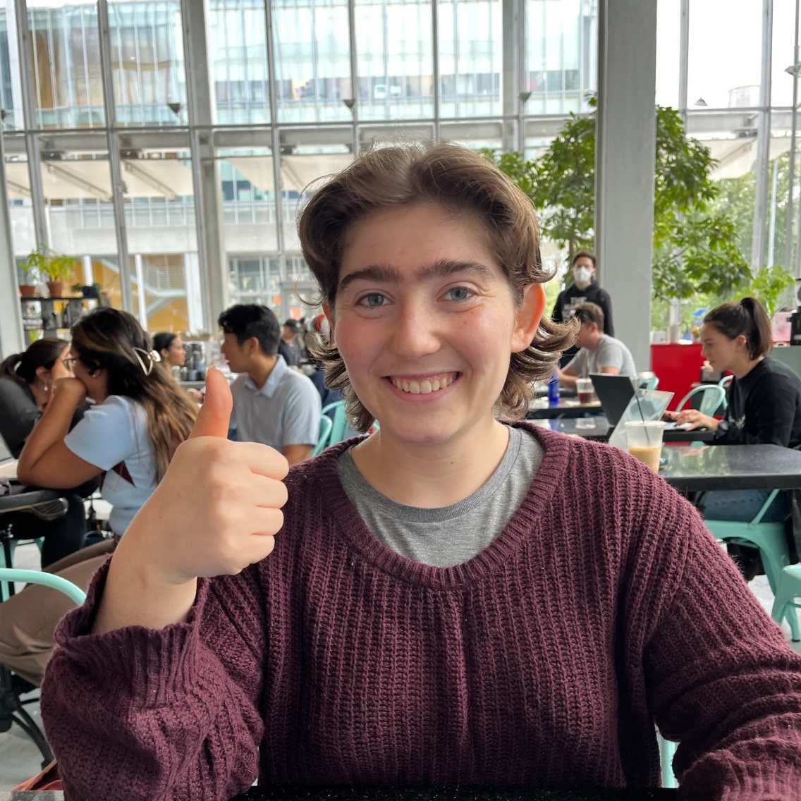 Photo of Ellie George smiling and giving a thumbs-up.