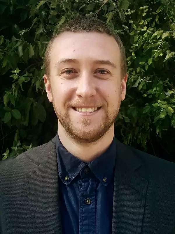 Man with beard smiling in outdoor setting