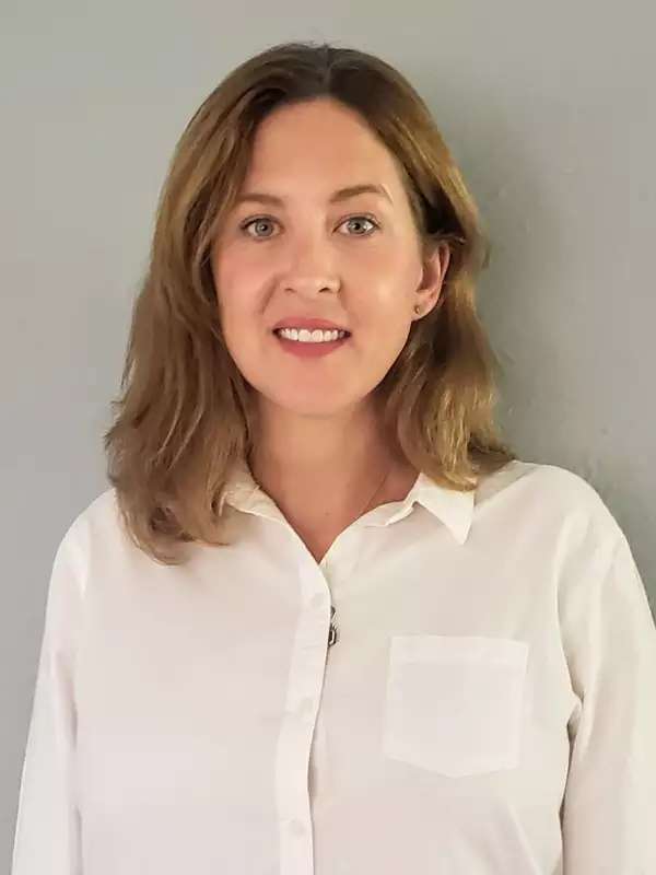 Woman with shoulder length-hair, wearing a white shirt